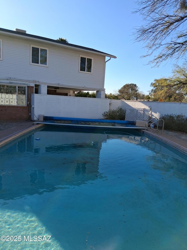 view of pool with a fenced in pool and fence