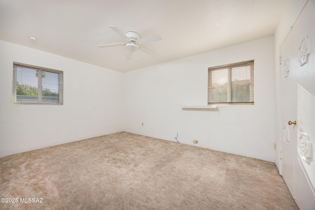 unfurnished room featuring a wealth of natural light, a ceiling fan, and carpet