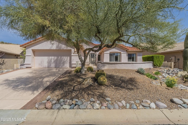view of front of house with a fenced front yard, a tile roof, concrete driveway, and stucco siding
