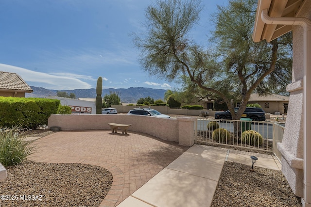 view of patio with a mountain view and fence