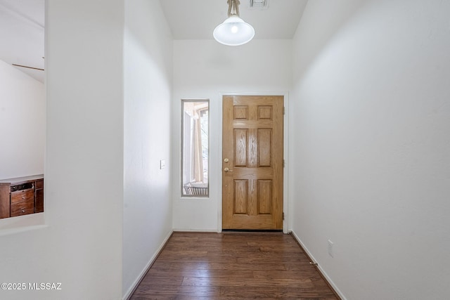 doorway to outside featuring baseboards and dark wood-style floors