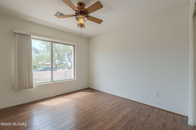empty room featuring ceiling fan, baseboards, and wood finished floors