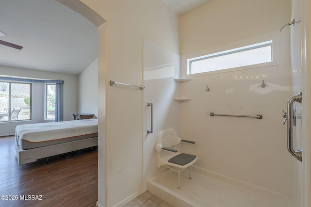 full bath featuring connected bathroom, a healthy amount of sunlight, wood finished floors, and a shower