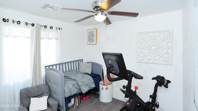 carpeted bedroom with a ceiling fan and visible vents