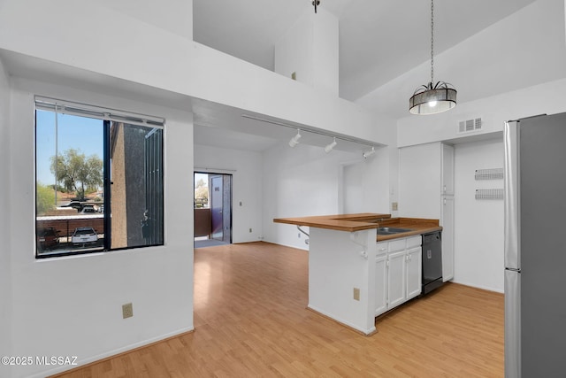 2172 N Pantano Rd Unit 217, Tucson, AZ 85715 - kitchen featuring freestanding refrigerator, white cabinetry, light wood finished floors, black dishwasher, and wood counters