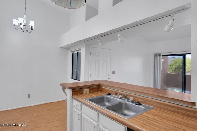 2172 N Pantano Rd Unit 217, Tucson, AZ 85715 - kitchen with rail lighting, a sink, white cabinets, and light countertops