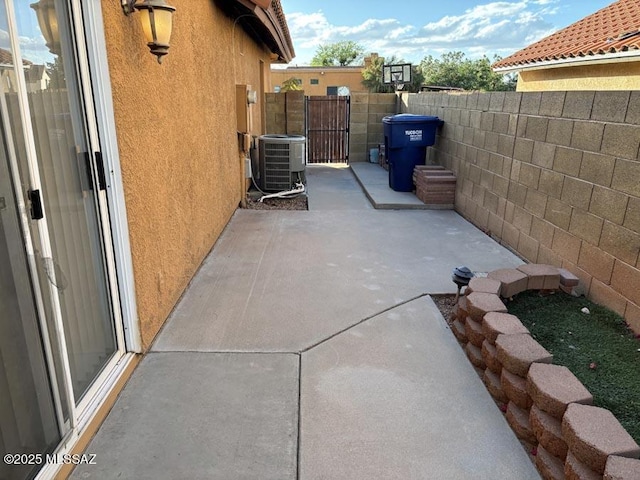 view of property exterior with a patio, stucco siding, fence, and cooling unit
