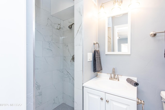 full bathroom featuring toilet, vanity, and tiled shower