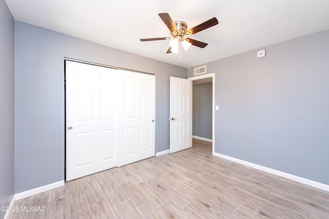 unfurnished bedroom featuring a closet, baseboards, light wood finished floors, and visible vents