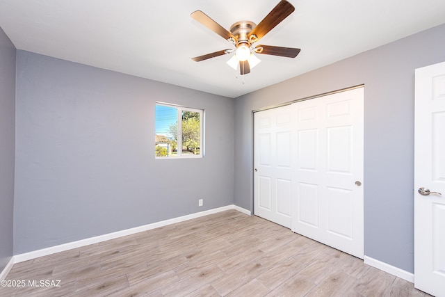 unfurnished bedroom with a closet, baseboards, light wood-style floors, and ceiling fan