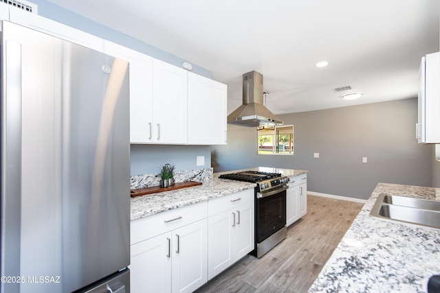 kitchen featuring white cabinetry, island range hood, stainless steel appliances, light wood-style floors, and visible vents