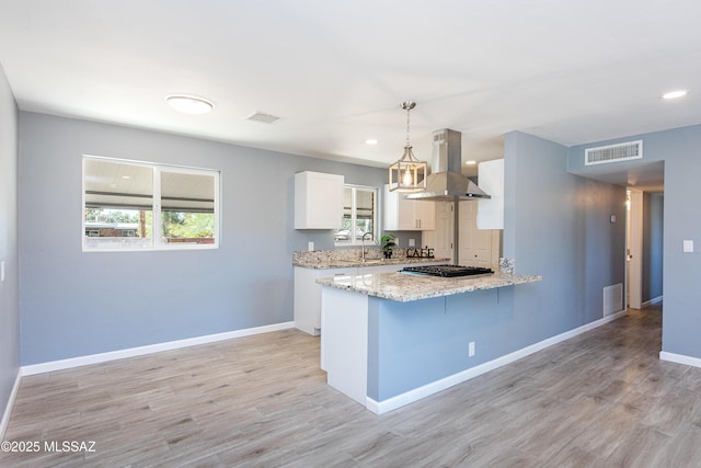 kitchen featuring visible vents, island exhaust hood, and a peninsula