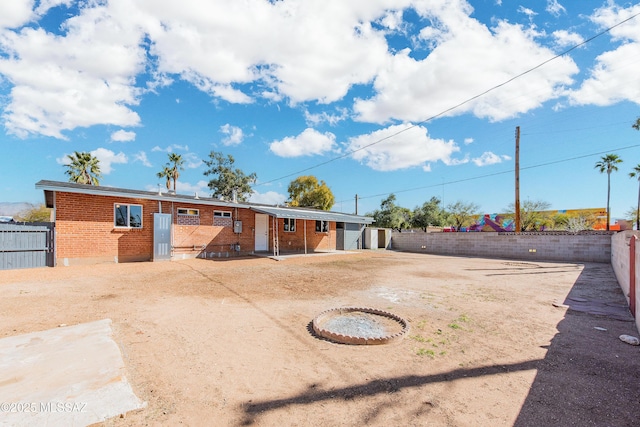 view of front of house featuring a fenced backyard and brick siding
