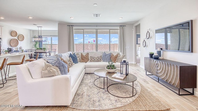 living room with wood finish floors, baseboards, and visible vents