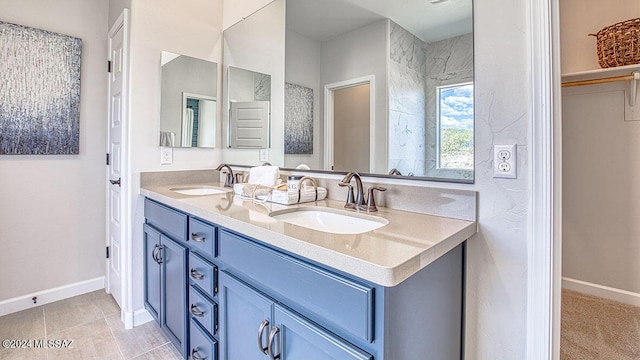 full bathroom featuring baseboards, double vanity, and a sink