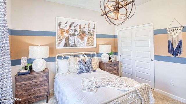 bedroom with baseboards, a closet, carpet, and an inviting chandelier