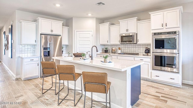 kitchen featuring light countertops, a sink, visible vents, white cabinets, and appliances with stainless steel finishes