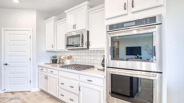 kitchen featuring light countertops, tasteful backsplash, wood finish floors, stainless steel appliances, and white cabinets