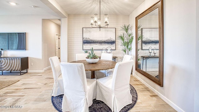 dining space with wood finish floors, baseboards, and a chandelier