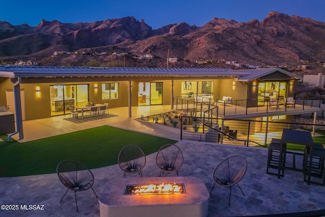 6800 N Cocopas Rd, Tucson, AZ 85718 - back of house featuring a fire pit, a mountain view, stucco siding, a patio, and a yard