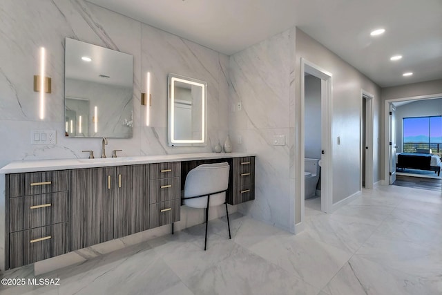 6800 N Cocopas Rd, Tucson, AZ 85718 - bathroom with marble look tiles, vanity, tile walls, toilet, and recessed lighting
