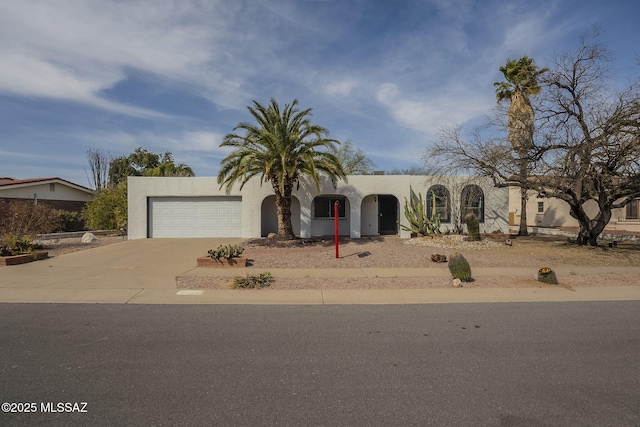 view of front of house featuring a garage, driveway, and stucco siding
