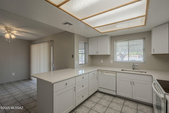 kitchen with a sink, a ceiling fan, white cabinetry, a peninsula, and white appliances
