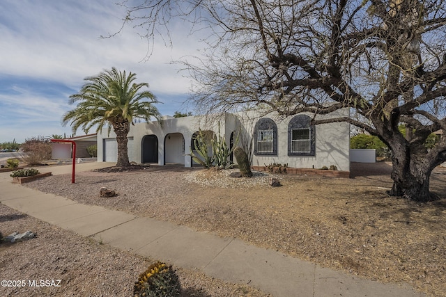 view of front of house featuring stucco siding, concrete driveway, and a garage