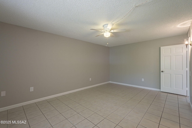 empty room featuring a textured ceiling, baseboards, and ceiling fan