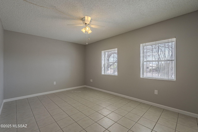 spare room with a textured ceiling, baseboards, and ceiling fan