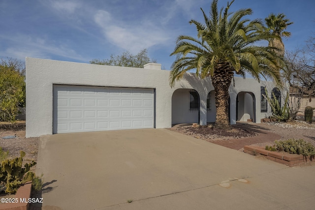 view of front facade featuring driveway, stucco siding, and an attached garage