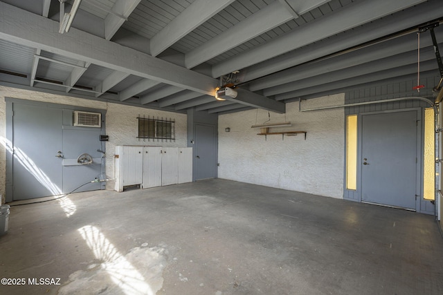 garage with a wall unit AC and a garage door opener