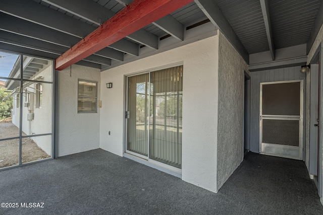 entrance to property featuring stucco siding and a patio area