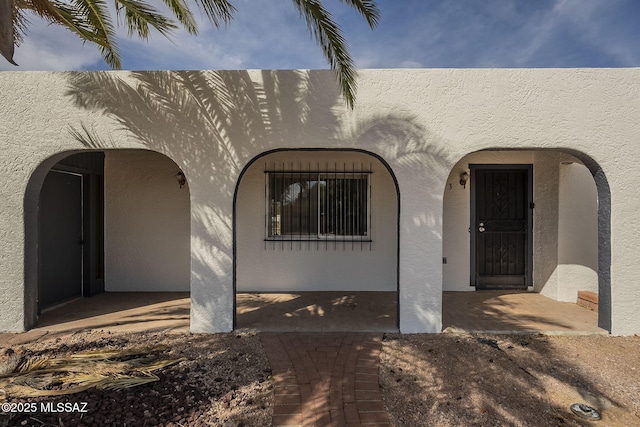 property entrance with stucco siding