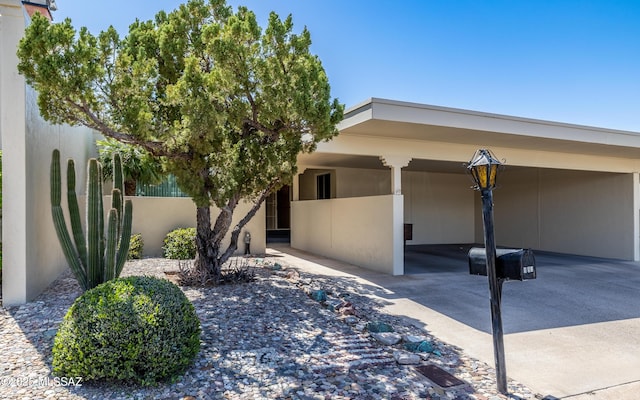 view of property exterior with a carport and stucco siding
