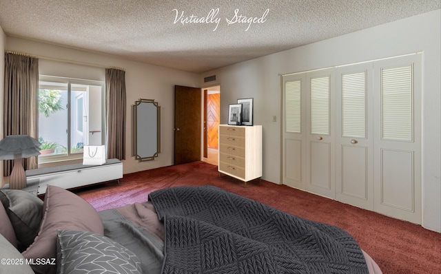 bedroom with dark carpet, a closet, visible vents, and a textured ceiling