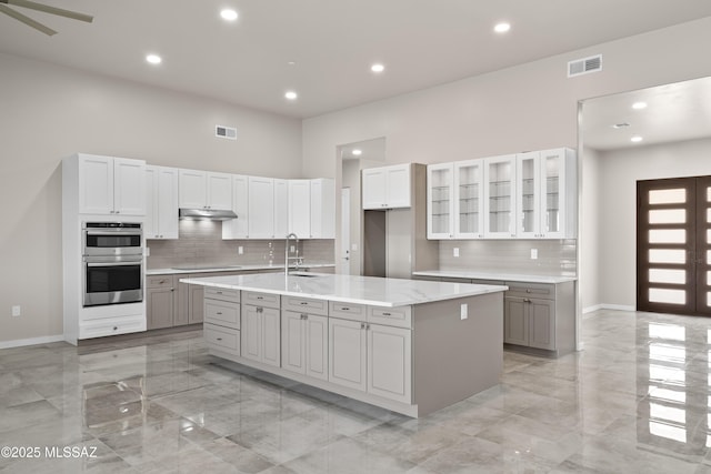 2891 N Wentworth Rd, Tucson, AZ 85749 - kitchen featuring marble finish floor, gray cabinetry, visible vents, and under cabinet range hood