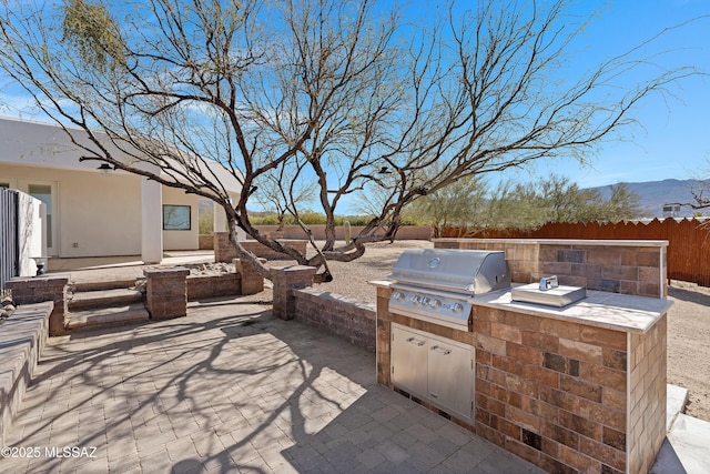 2891 N Wentworth Rd, Tucson, AZ 85749 - view of patio / terrace featuring an outdoor kitchen, area for grilling, a mountain view, and fence