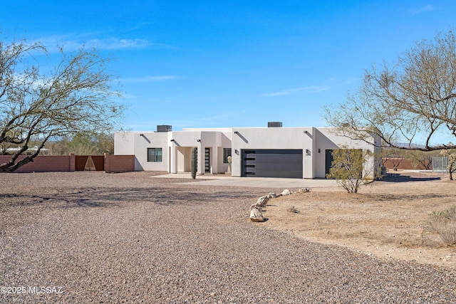 2891 N Wentworth Rd, Tucson, AZ 85749 - pueblo-style house featuring fence, driveway, stucco siding, and a garage