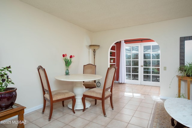 1194 S Alpine Cir, Green Valley, AZ 85614 - dining room featuring arched walkways, baseboards, french doors, and light tile patterned floors