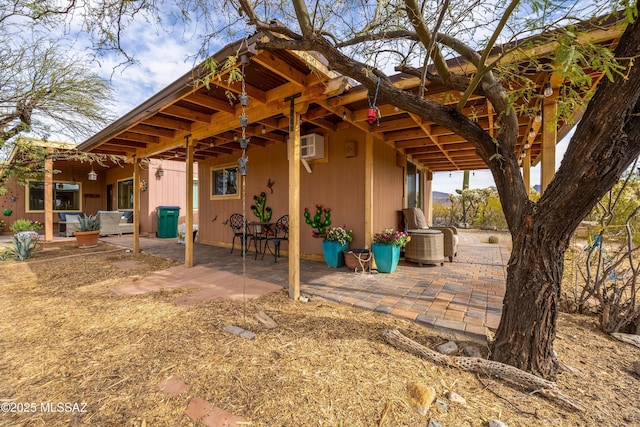rear view of house with a patio area and a wall mounted air conditioner