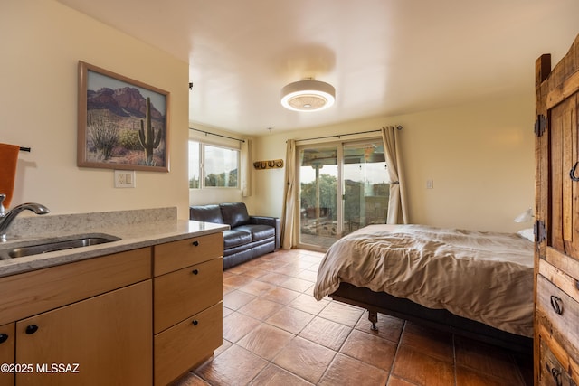 bedroom featuring a sink, light tile patterned floors, and access to exterior