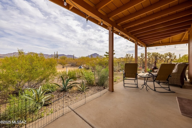 view of patio / terrace with fence and a mountain view