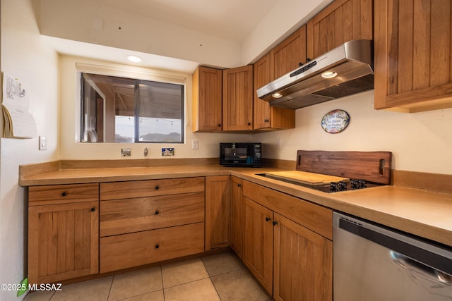 kitchen with light tile patterned floors, light countertops, under cabinet range hood, brown cabinets, and black appliances