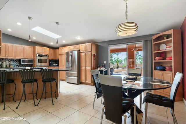 dining space featuring recessed lighting, lofted ceiling with skylight, and light tile patterned floors