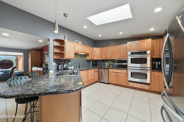 kitchen with a kitchen breakfast bar, a peninsula, appliances with stainless steel finishes, open shelves, and backsplash