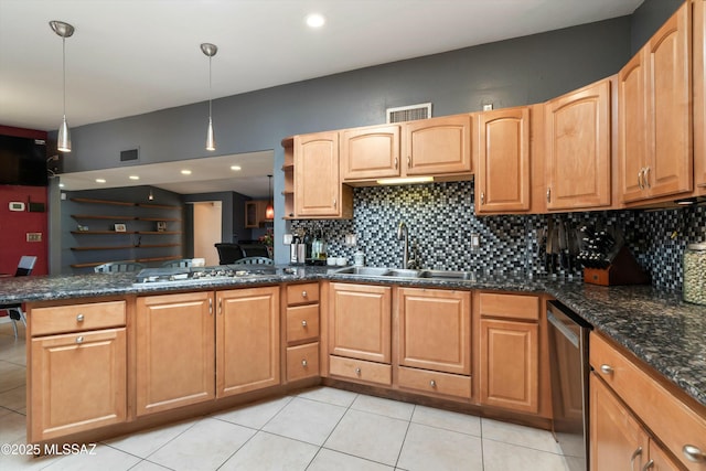 kitchen with backsplash, a peninsula, a sink, and stainless steel appliances