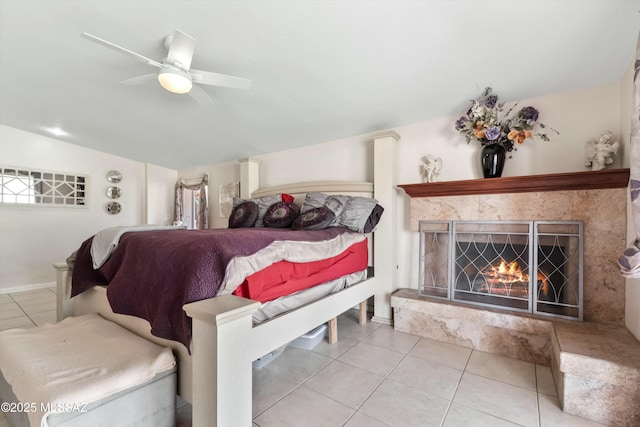 tiled bedroom with vaulted ceiling, ceiling fan, and a fireplace