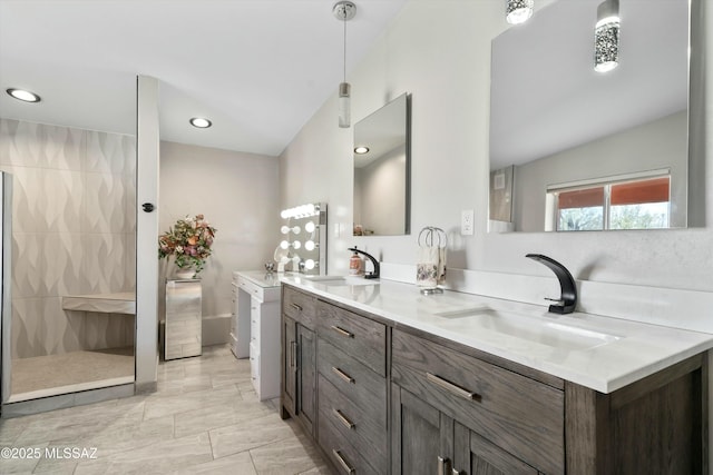 bathroom featuring double vanity, a tile shower, a sink, and vaulted ceiling