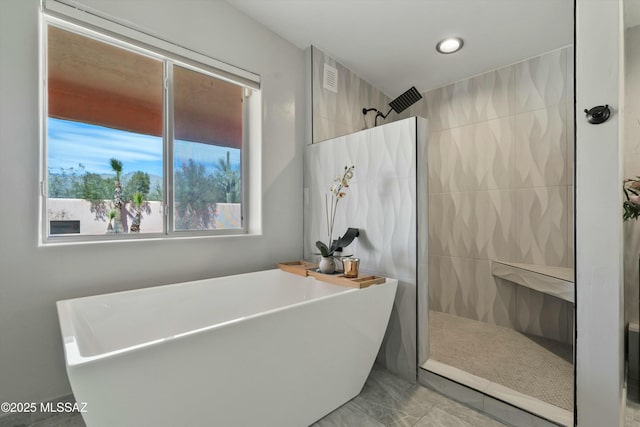 bathroom featuring a walk in shower and a soaking tub